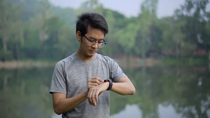 亚洲男子使用hr智能手表练习跑步