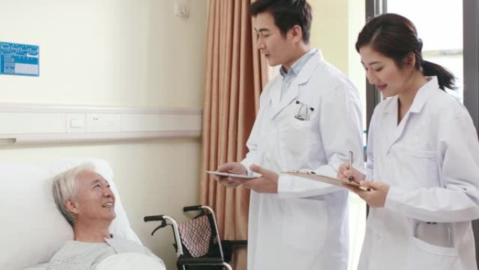 亚洲医生在医院病房与老人病人交谈