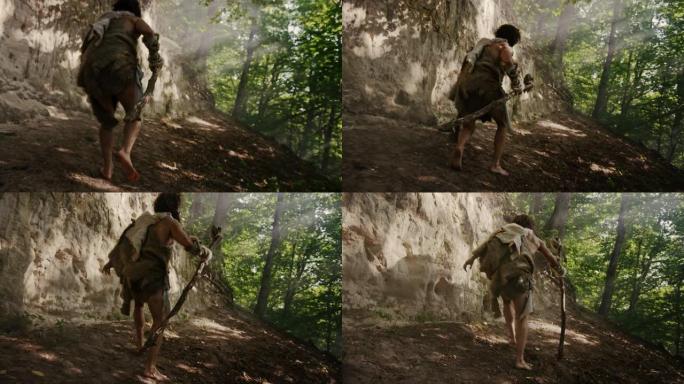 穿着动物皮的原始穴居人手持石尖锤环顾四周，探索史前森林，准备猎杀动物猎物。尼安德特人去丛林打猎。后视