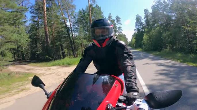 摩托车手戴着头盔在公路上快速行驶。