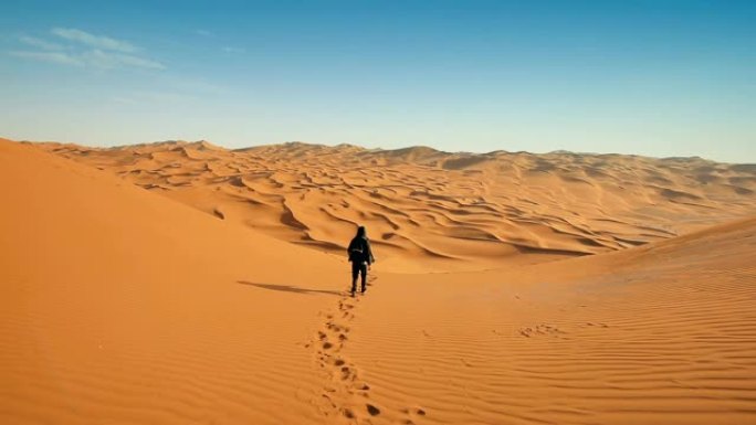 在沙漠上行走的男性游客