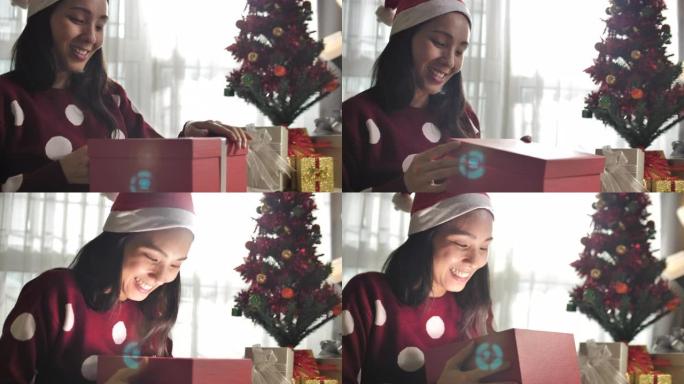 年轻的亚洲妇女在圣诞节庆祝活动中打开了一个发光的礼品盒