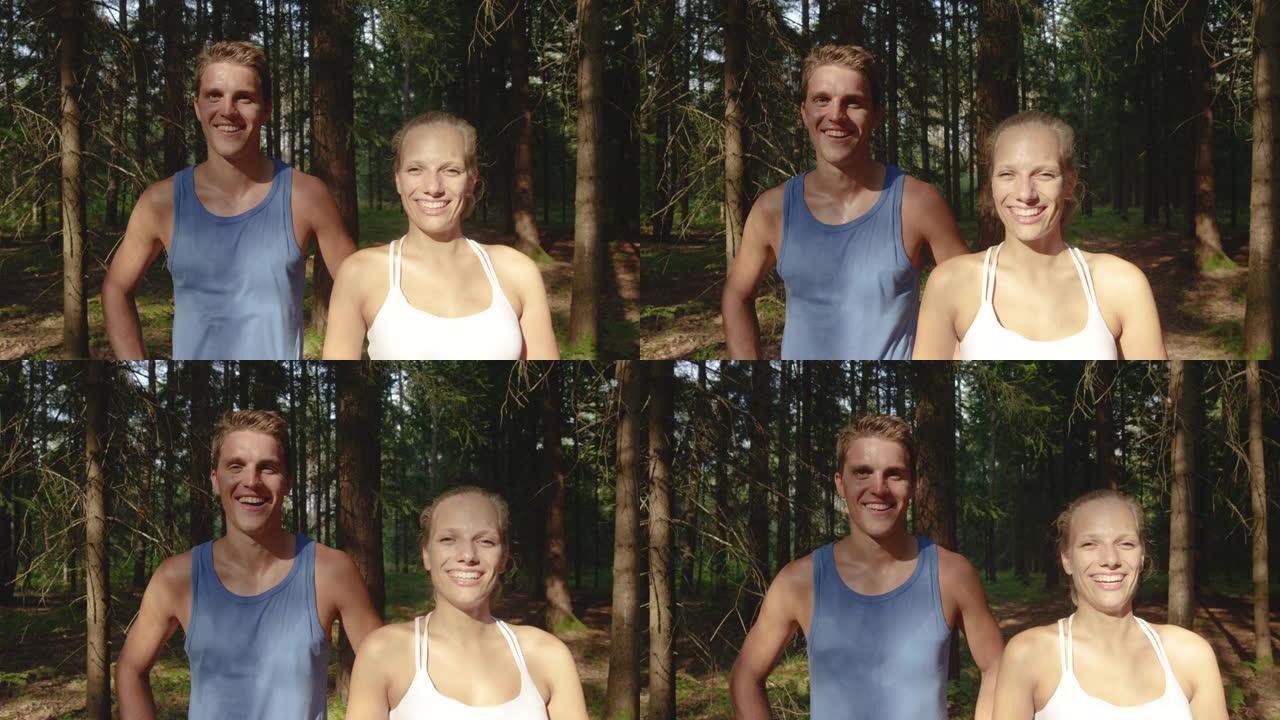 慢动作: 微笑的训练伙伴慢跑后站在森林前。