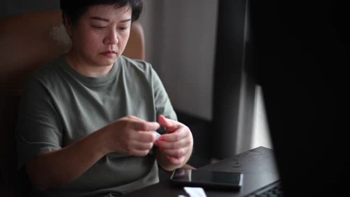 一位亚洲华人女性在房间里用完手机后擦拭手机