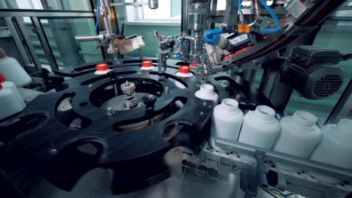 自动化机器在瓶子、工厂转换时盖上盖子。