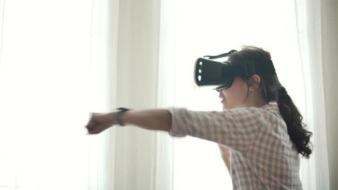 亚洲女子戴VR眼镜在家玩游戏