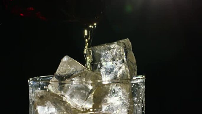 威士忌以慢动作，微距拍摄的方式倒入装有冰的玻璃杯中，放在木桌和深色背景上。