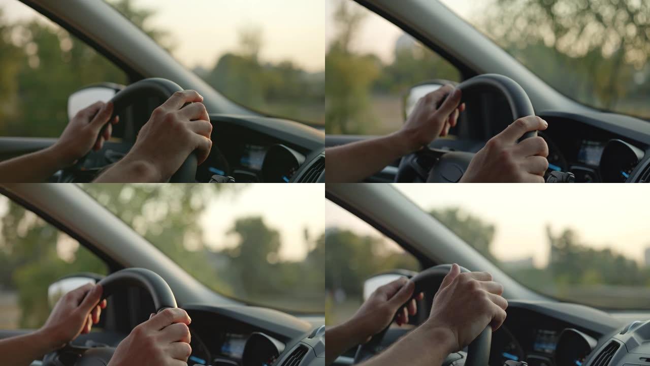 日落时在乡村公路上开车。手在方向盘上的特写镜头。4K, UHD