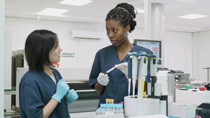 年轻的病理妇女显示同事在实验室组织血液样本