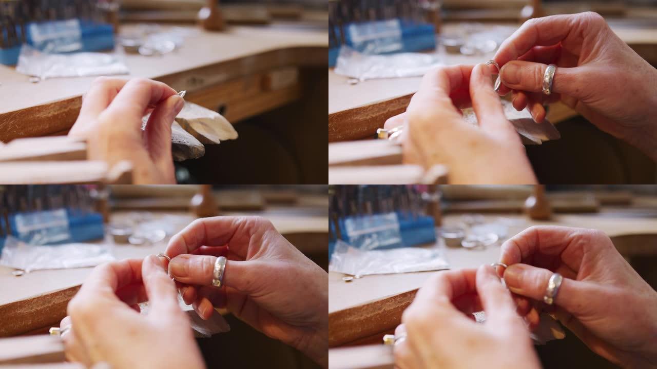 工作室里在戒指上工作的女性珠宝商的特写