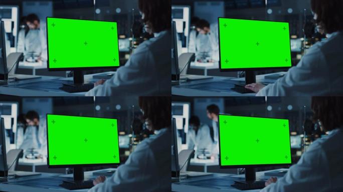肩膀上的镜头: 女IT科学家使用绿色模拟屏幕计算机。在背景技术研究与开发实验室中，科学家，从事高科技