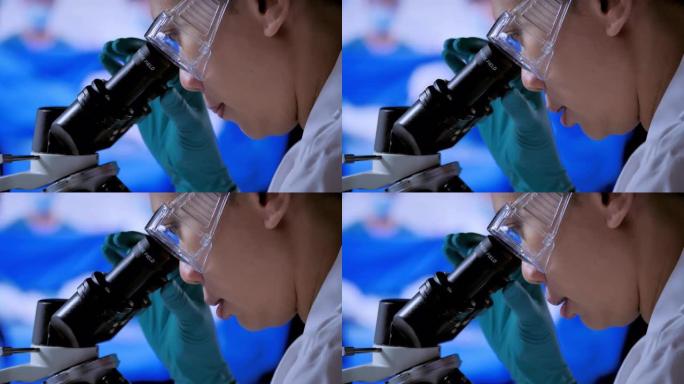 亚洲年轻女子在显微镜中寻找焦点从病毒到实验室技术与冠状病毒病毒或Covid-19.Science，医