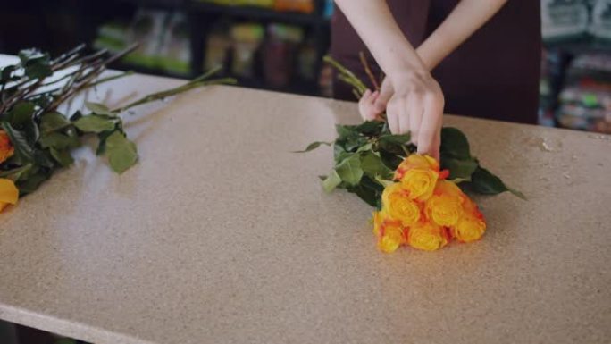 鲜花女售货员在商店里制作美丽的玫瑰成分