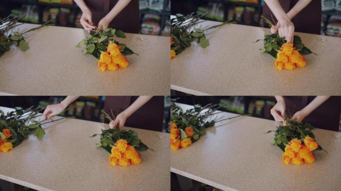 鲜花女售货员在商店里制作美丽的玫瑰成分