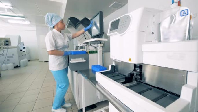 制药实验室工作人员在机器的监视器上进行类型，进行血液样本测试。