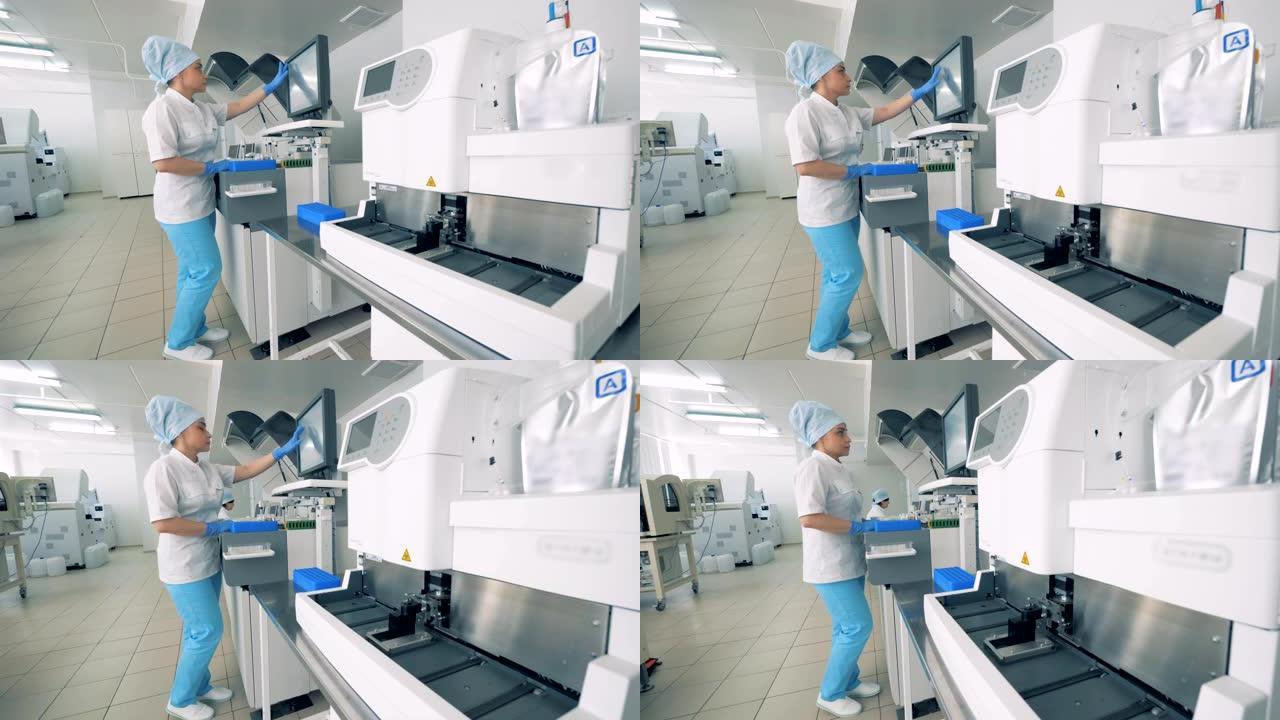 制药实验室工作人员在机器的监视器上进行类型，进行血液样本测试。