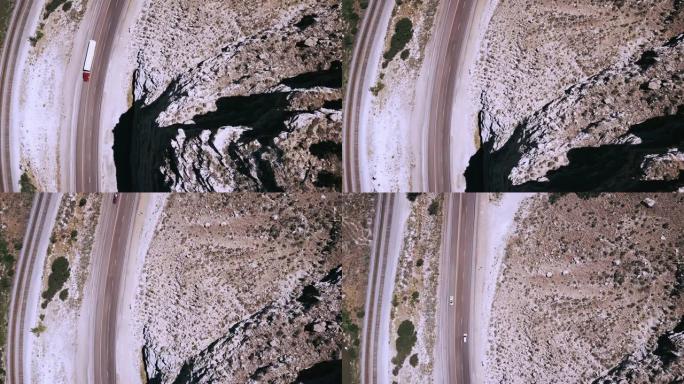 俯视图无人机在美丽的高速公路和铁轨上右转，靠近史诗般的岩石砂岩山。