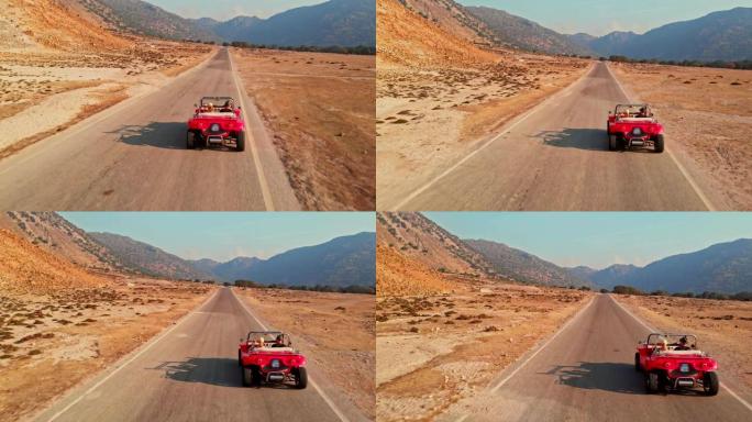 红色cabrio汽车在沙漠道路上行驶，鸟瞰图