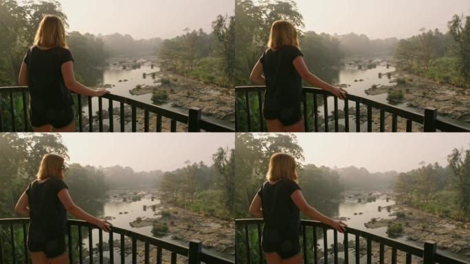 女士在阳台上看着斯里兰卡田园诗般的河景