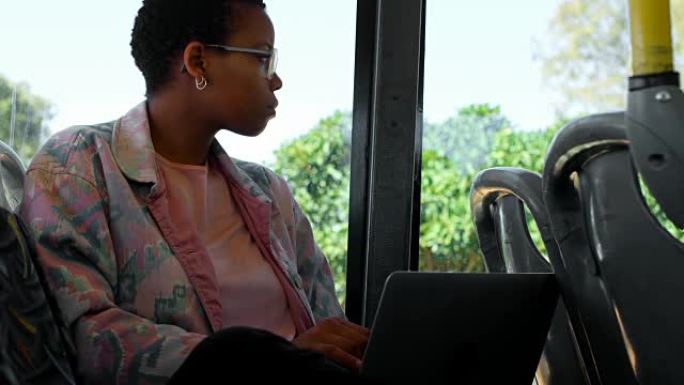 通勤者在4k公交车上使用笔记本电脑时透过窗户看