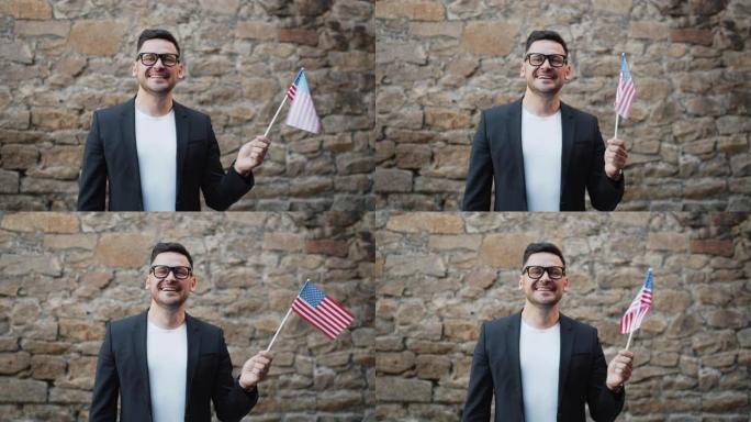 肖像快乐的美国人挥舞着美国官方旗帜在户外微笑