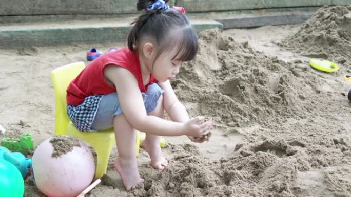 可爱的儿童女孩在操场上玩沙子
