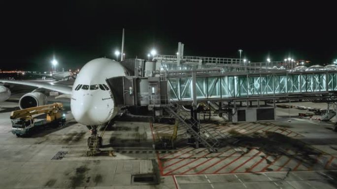 4k分辨率商用飞机在机场航站楼门口与旅客站在一起的夜间时间流逝