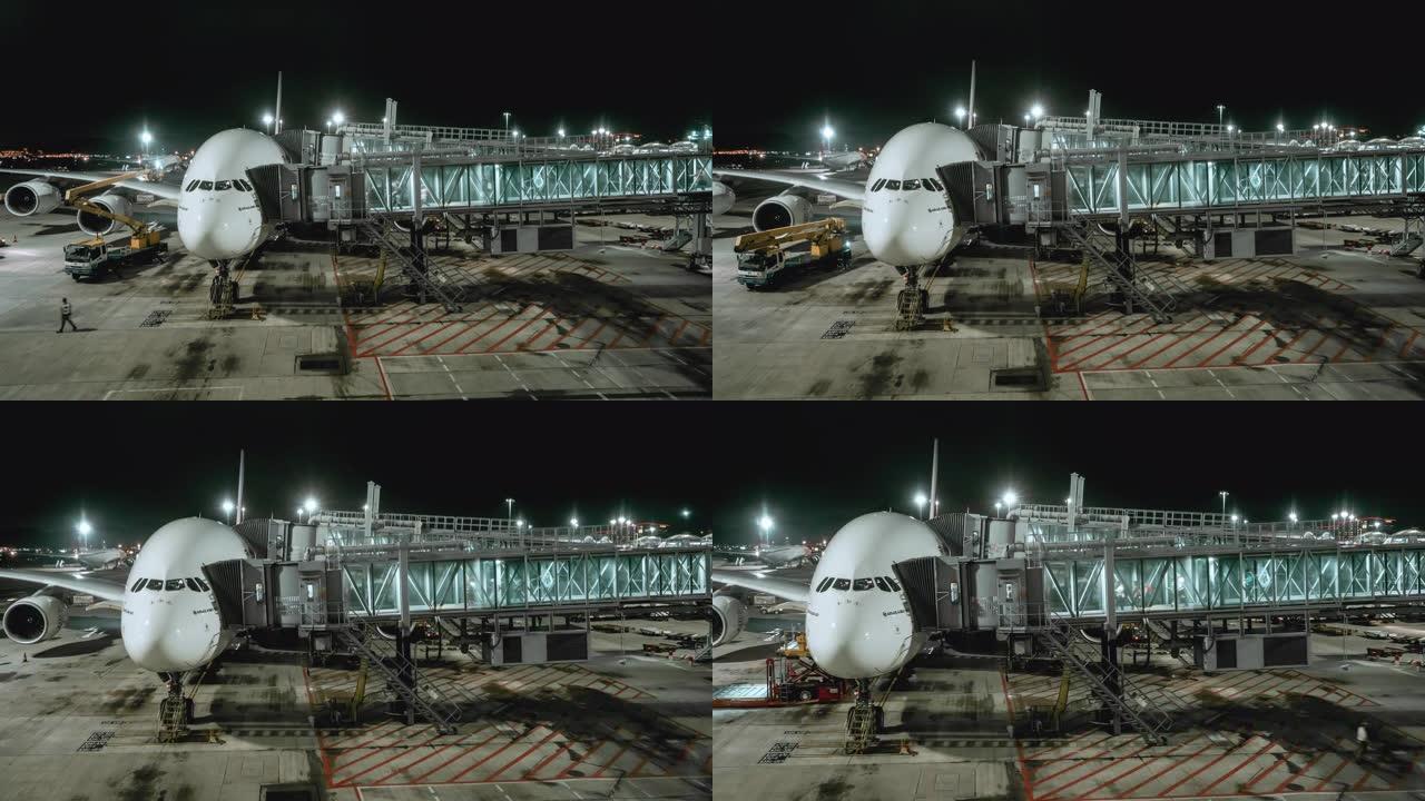 4k分辨率商用飞机在机场航站楼门口与旅客站在一起的夜间时间流逝