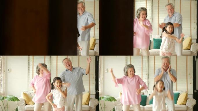 快乐的亚洲老年夫妇和孙女一起在家跳舞。高级生活方式家庭概念。