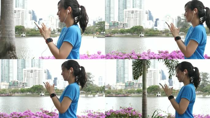 亚洲运动女性走路和使用智能手机