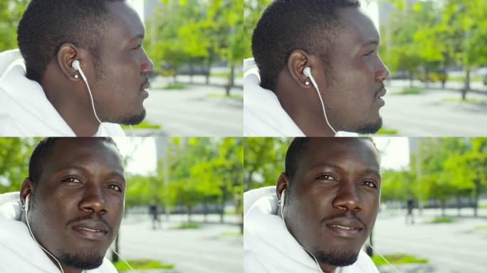 戴着耳机的非洲男子在户外摆姿势拍照