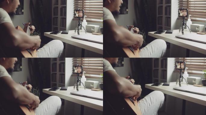 亚洲男子在家中学习弹吉他