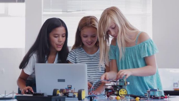三名女学生在课后计算机编码课上建造和编程机器人车辆