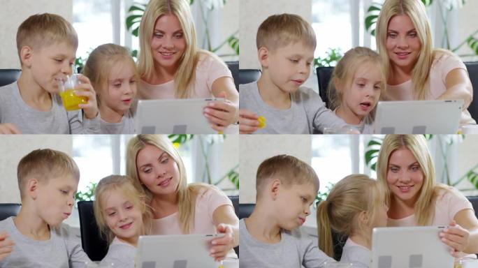 早餐时快乐的孩子和妈妈一起使用平板电脑