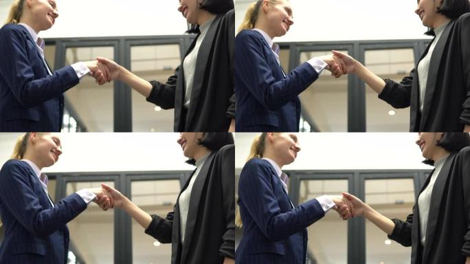 两名女性商业伙伴握手，达成有利可图的协议，合作