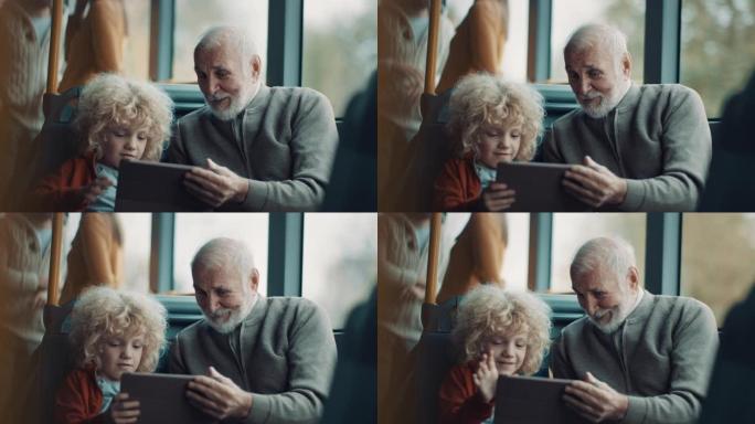 祖父和孙子一起乘坐公共汽车时使用平板电脑