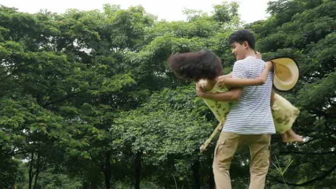 男人在公园里旋转女友，爱情概念。