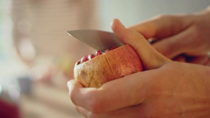 一名男子用锋利的菜刀切石榴的特写镜头。在现代厨房准备健康的有机素食小吃。天然清洁饮食和健康的生活理念