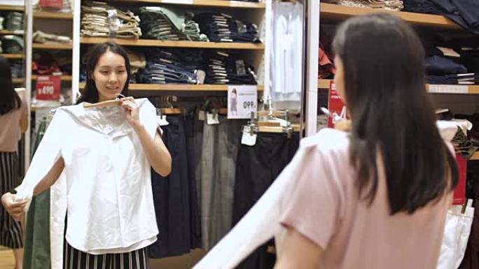 亚洲妇女在服装店试穿衣服