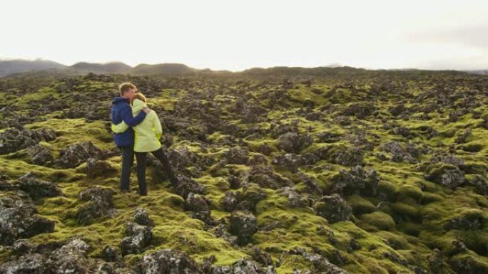 MS夫妇站在冰岛偏远景观的苔藓覆盖的岩石中