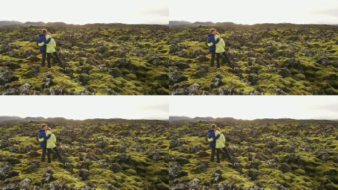 MS夫妇站在冰岛偏远景观的苔藓覆盖的岩石中