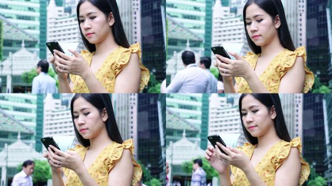 新加坡莱佛士广场的亚洲女性发短信智能手机。