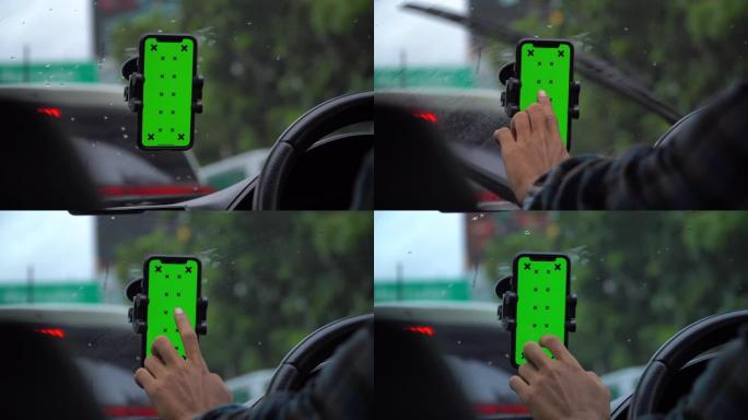 驾驶员手在汽车上使用智能手机，绿屏