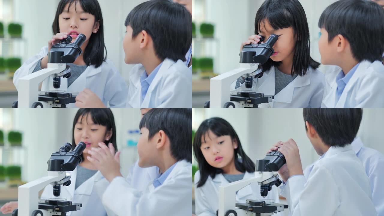 理科学生在学校的实验室里用显微镜看孩子。老师和好奇的学生在教室实验室进行科学实验。教育，技术，团队合