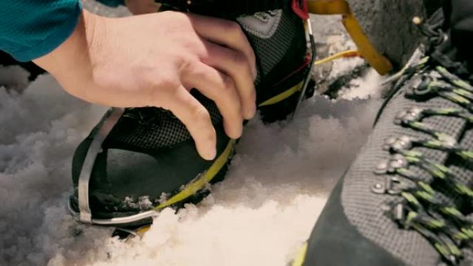 准备在雪地上攀登。将冰爪安装在靴子上