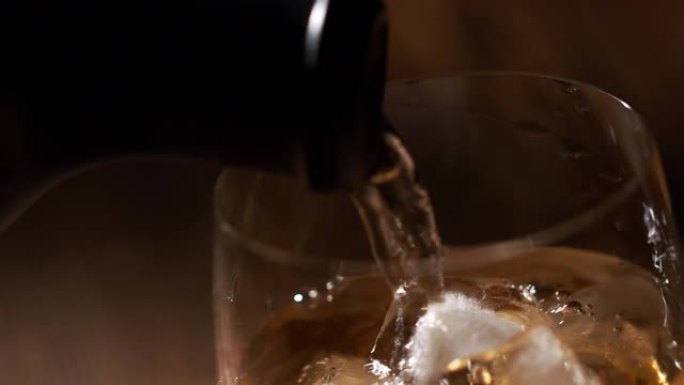 一杯威士忌，冰块和瓶子放在木制桌子上，背景是木制的