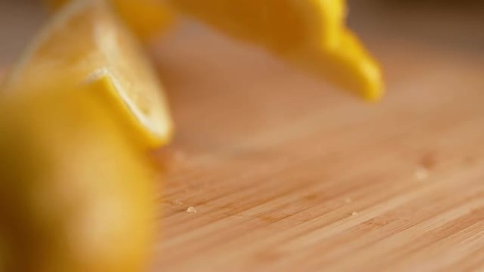 宏观: 芳香明亮的黄色柠檬四分之一落在木制砧板上。