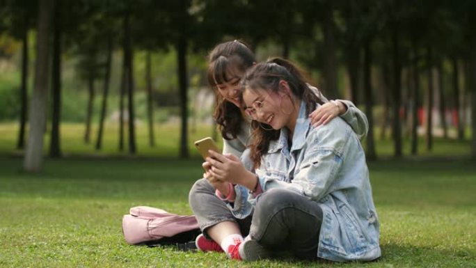 两名亚裔女大学生在校园内使用手机