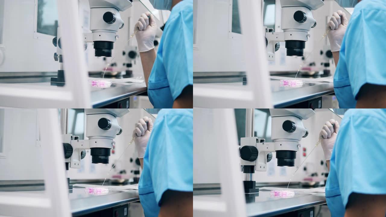 化学实验室工作人员正在显微镜下用物质填充管子