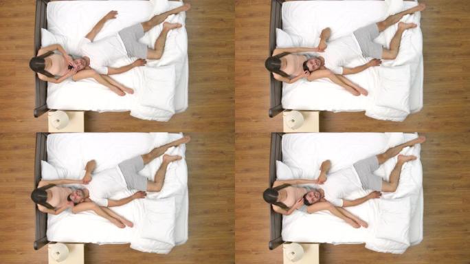 女人在床上为男人做头部按摩。从上方观看